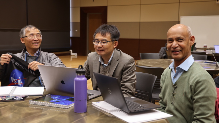 Three people at a table in a meeting room