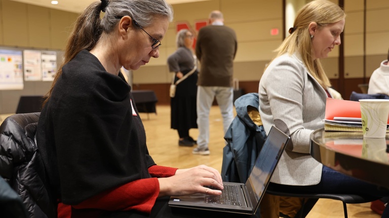 Person working on a laptop at a conference
