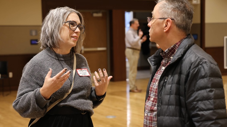 Two people talking at a conference