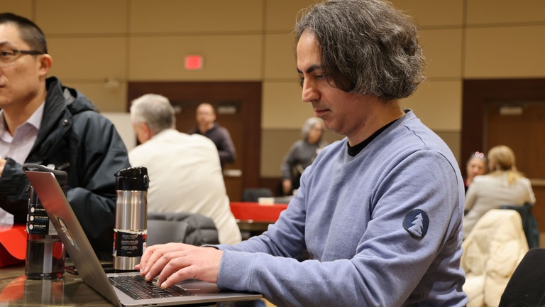 A person working on a laptop at a conference